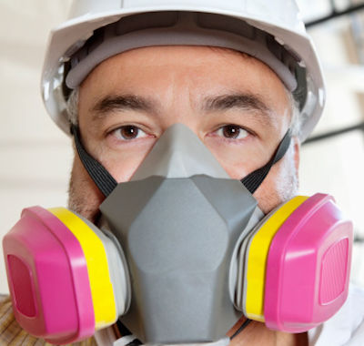 Image showing an employee wearing a half-face respirator and safety helment