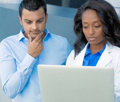 Image showing two employees looking at information on a computer