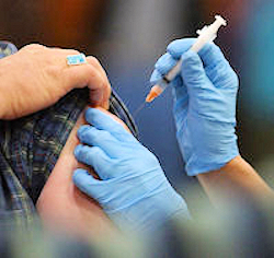 Nurse giving a patient receiving the hepatitis B shot.