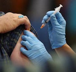 Healthcare worker giving a shot in the arm to a patient.