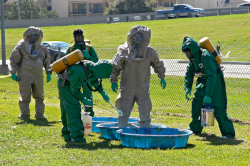 Three Workers assisting two co-workers with decontamination