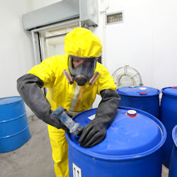 employee in full PPE working with chemicals stored safely and securely