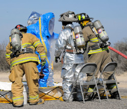 workers wearing level B protection decontaminating  one worker wearing level A protection