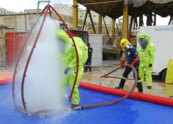 Worker in Level A protective suit being decontaminated