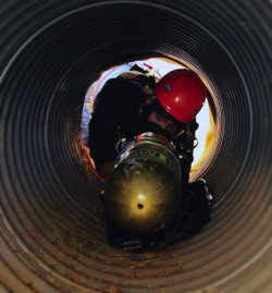 Worker using equipment to check for hazardous conditions in a confined space