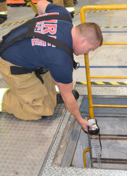 worker testing the atmosphere of a confined space