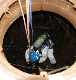 Worker entering a large dark confined space