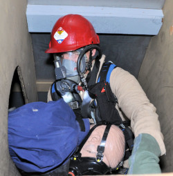 Workers training for rescue in a confined space