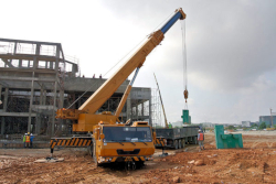 Mobile crane lifting material at construction site