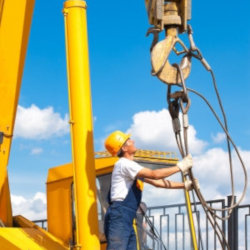 worker inspecting large crane