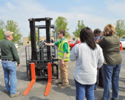 group workers outdoors  receiving forklift training