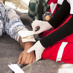 First aid being performed on an injured person's lower arm