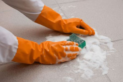 cleaning the floor while wearing gloves for PPE