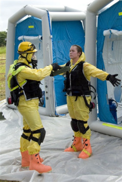 one Worker being decontaminated by another outside hazard zone