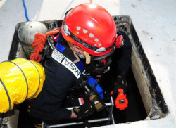 Person in full protective gear enters a confined space.