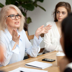 Image of employees sitting around a table practing good communication