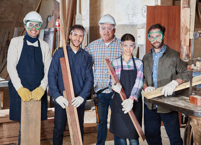 Five construction workers having a photo taken at their work site