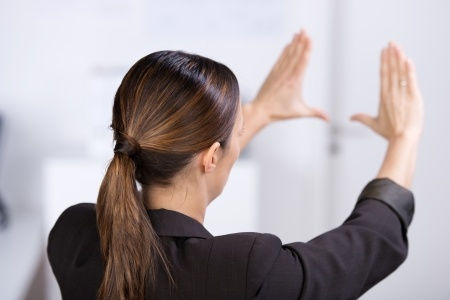 Woman holding hands up to form a square as if framing a situation