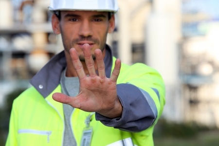 Worker facing camera with hand up in the stop motion