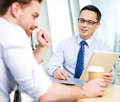 Two workers at a desk with a open laptop cooperating without fear