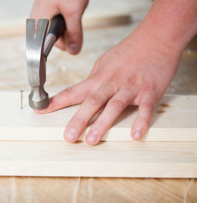 Man with hammer head on index finger