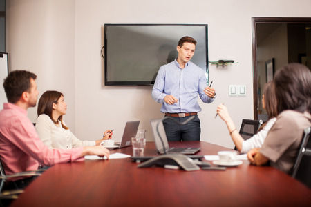 Employees at meeting with leader up front directing conversation