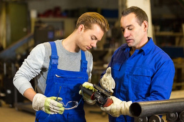 Two employees inspecting a tool