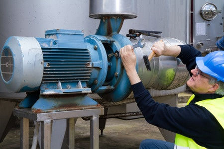 Worker performing preventive maintenance on large motor