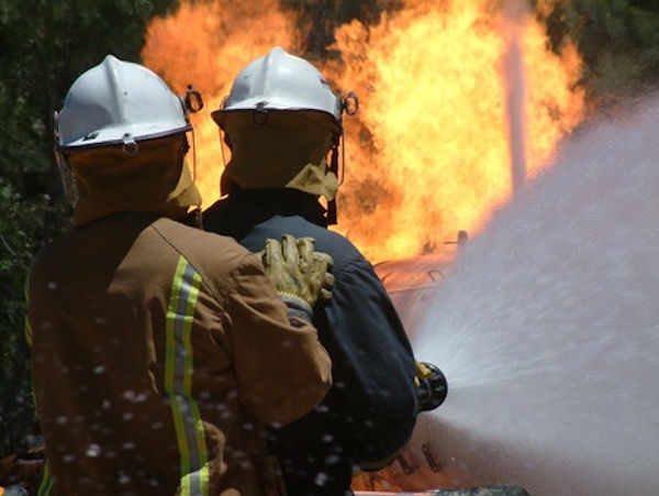 Two firemen fighting building fire