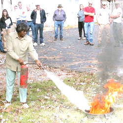 A group of workers outside receiving fire extinguisher training