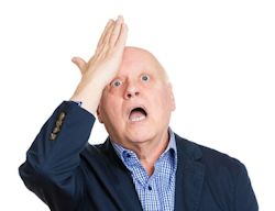 Man raising hand to head with surprised look on face