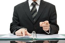 Man in suit with notebook pointing his finger