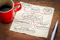 Cup of coffee and a pen on table with paper suggesting conflict resolution ideas