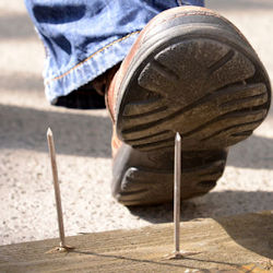 worker wearing safety shoes about to step on a nail safety shoes