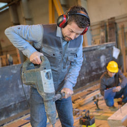 Worker using heavy jackhammer tool