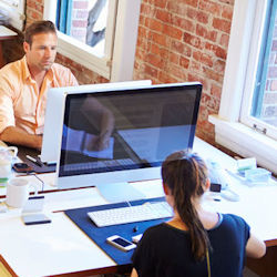 Two workers facing their computer screens.