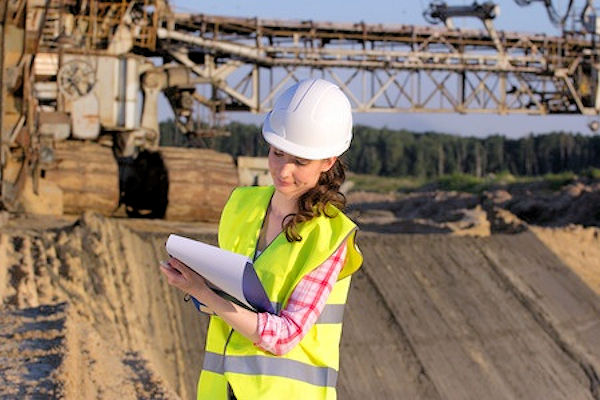 Inspector outside worksite taking notes.