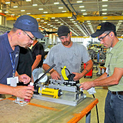 Three workers going through on the job training.