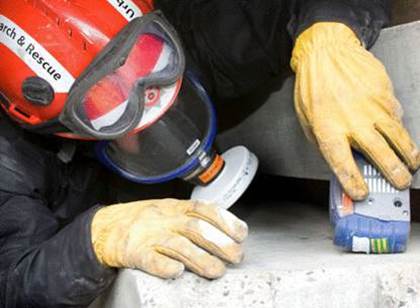 Worker with PPE and respirator evaluating a confined space.