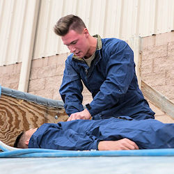 Rescuer applying first aid to another worker.