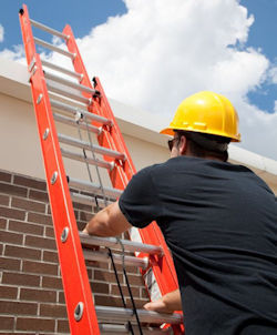 Worker climbing extension ladder