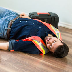 worker laying on surface after falling from ladder