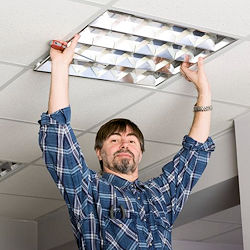 Electrical Worker on ladder working on ceiling light.