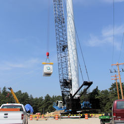 Crane lifting box dangerously close to powerlines.