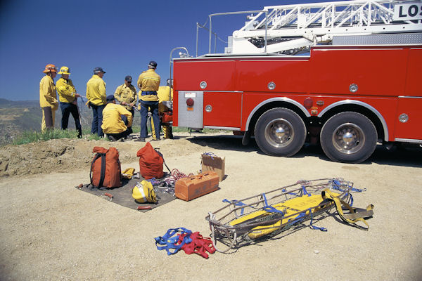 Group of first responders around a fire truck holding a practice drill.