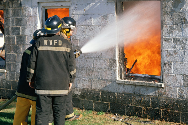 Three firemen fighting a house fire