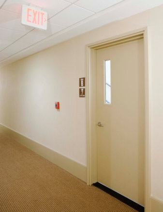 Exit door with exit sign above on the ceiling.