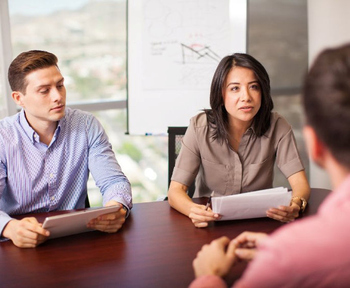 Image of two investigators interviewing an employee