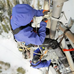 two workers on a tower during a very cold day