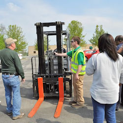 trainer reviewing forklift parts with employees